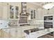 A close-up view showcases the stainless steel range hood and appliances, complemented by custom cabinetry and countertop details at 7605 Haddington Cv, Lakewood Ranch, FL 34202