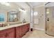 A luxurious main bathroom is equipped with dual sinks, granite countertops, and a glass-enclosed shower at 7605 Haddington Cv, Lakewood Ranch, FL 34202