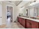 Vanity with granite countertops and a large, decorative mirror in the main bathroom of the home at 7605 Haddington Cv, Lakewood Ranch, FL 34202