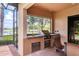 Outdoor kitchen area with a built-in sink and grill, surrounded by brick flooring at 7605 Haddington Cv, Lakewood Ranch, FL 34202