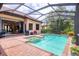 Outdoor swimming pool with spa, brick patio, screened enclosure, and lush landscaping at 7605 Haddington Cv, Lakewood Ranch, FL 34202