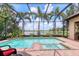 Screened-in pool and spa overlook a serene lake view, creating a relaxing outdoor oasis at 7605 Haddington Cv, Lakewood Ranch, FL 34202