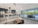 Open-concept living area with modern furnishings, opening to kitchen and outdoor patio with pool at 8009 20Th W Pl, Bradenton, FL 34209