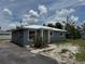 Side view of a single-story house with a metal roof and tidy landscaping at 811 24Th Street E Ct, Bradenton, FL 34208