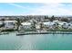 Exterior view of waterfront homes, docks, and a community pool with city views in the distance at 999 Inlet Cir # 103, Venice, FL 34285