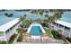 Aerial view of the community pool surrounded by lounge chairs and lush landscaping at 999 Inlet Cir # 103, Venice, FL 34285