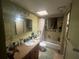 Functional bathroom features a vanity, mirror and bathtub with shower, illuminated by a skylight at 11234 Areca Dr, Port Richey, FL 34668