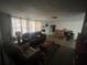 Cozy living room features a dark leather sofa, neutral walls and lots of natural light at 11234 Areca Dr, Port Richey, FL 34668