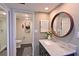 Clean bathroom with marble vanity, round mirror, and a tiled walk-in shower at 1510 1St W Ave # 102, Bradenton, FL 34205