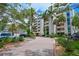 Beautiful condo building with tropical landscaping and a circular driveway leading to the main entrance at 1510 1St W Ave # 102, Bradenton, FL 34205
