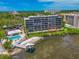 Stunning waterfront condo building featuring a pool, beach access, and lush landscaping at 1510 1St W Ave # 102, Bradenton, FL 34205