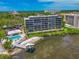 Stunning waterfront condo building featuring a pool, beach access, and lush landscaping at 1510 1St W Ave # 102, Bradenton, FL 34205
