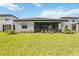 Well-manicured backyard with lush green grass and a covered lanai at 15115 Oxford Grey Dr, Bradenton, FL 34211