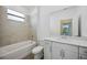 Bright bathroom featuring neutral tile, a tub-shower combination, and white vanity at 15115 Oxford Grey Dr, Bradenton, FL 34211