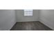 Minimalist bedroom with wood-look tile floors and a window for natural light at 15115 Oxford Grey Dr, Bradenton, FL 34211