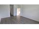 Empty bedroom with wood-look tiling and access to bathroom and another room at 15115 Oxford Grey Dr, Bradenton, FL 34211