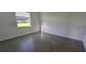 Bedroom featuring wood-look flooring and a window overlooking the yard at 15115 Oxford Grey Dr, Bradenton, FL 34211