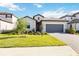 Inviting single-story home featuring a paved driveway, two-car garage, and manicured landscaping at 15115 Oxford Grey Dr, Bradenton, FL 34211
