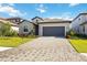 Single-story home with a paver driveway, a two-car garage, and well-maintained landscaping at 15115 Oxford Grey Dr, Bradenton, FL 34211