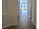 Bright hallway featuring wood-look tile floors and views of the backyard at 15115 Oxford Grey Dr, Bradenton, FL 34211