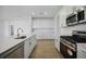 Modern kitchen boasts stainless steel appliances and sleek white cabinetry at 15115 Oxford Grey Dr, Bradenton, FL 34211