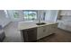Kitchen island with sink, dishwasher, and white cabinets offers ample storage at 15115 Oxford Grey Dr, Bradenton, FL 34211