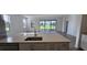 Spacious kitchen featuring a large island with a sink, dishwasher, and white cabinets at 15115 Oxford Grey Dr, Bradenton, FL 34211
