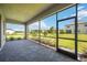 Screened lanai featuring brick flooring and views of the manicured backyard at 15115 Oxford Grey Dr, Bradenton, FL 34211