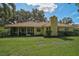 Backyard exterior with a view of the sunroom, backyard, and well-maintained landscaping at 1674 Cottonwood Trl, Sarasota, FL 34232