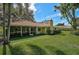 Exterior view showcasing the home's sunroom and lush backyard space at 1674 Cottonwood Trl, Sarasota, FL 34232