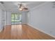 Light-filled bedroom with wood floors, natural paint, ceiling fan, and sliding doors to the lanai at 1674 Cottonwood Trl, Sarasota, FL 34232