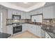 Bright kitchen boasts stainless steel appliances, tile flooring, white cabinets, and a decorative backsplash at 1674 Cottonwood Trl, Sarasota, FL 34232