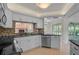 Bright kitchen boasts stainless steel appliances, tile flooring, white cabinets, and granite countertops at 1674 Cottonwood Trl, Sarasota, FL 34232