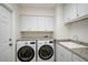 Functional laundry room featuring a granite countertop, sink, and washer and dryer at 1674 Cottonwood Trl, Sarasota, FL 34232