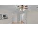 Living room with a ceiling fan and an opening to the kitchen with tiled floors and white walls at 1674 Cottonwood Trl, Sarasota, FL 34232