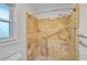 Walk-in shower featuring stone tile, grab bars, and an adjustable shower head at 1674 Cottonwood Trl, Sarasota, FL 34232