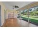 Inviting sunroom with tile flooring, ceiling fan, and screened windows overlooking the lush backyard at 1674 Cottonwood Trl, Sarasota, FL 34232