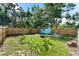 A large backyard with lush green grass, mature trees, a wooden fence, and a shed at 1911 26Th W St, Bradenton, FL 34205