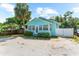 Charming light blue single-story home showcasing ample windows and a well-kept yard, complemented by a mature palm tree at 1911 26Th W St, Bradenton, FL 34205