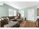 Inviting living room with hardwood floors, a large sectional sofa, and ample windows for natural light, creating a cozy ambiance at 1911 26Th W St, Bradenton, FL 34205