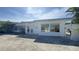 Exterior view of the house with white paint, big windows, and circular driveway at 205 55Th Ave, St Pete Beach, FL 33706