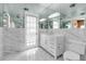 Stylish bathroom with marble finishes, a sleek vanity, mirrored walls, and a glass-enclosed shower at 259 S Polk Dr, Sarasota, FL 34236