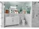 Elegant bathroom featuring marble finishes, a spacious vanity, mirrored walls, and a walk-in shower at 259 S Polk Dr, Sarasota, FL 34236