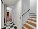 Hallway with black and white floors leads to wooden stairs with modern black banister at 259 S Polk Dr, Sarasota, FL 34236