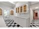 Kitchen area with white cabinets and black and white checkered flooring, with a back door to an outside porch at 259 S Polk Dr, Sarasota, FL 34236