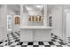 Additional view of the bright kitchen, featuring a large counter, white cabinetry, and a classic black and white floor at 259 S Polk Dr, Sarasota, FL 34236
