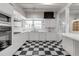 Bright kitchen with white cabinets, brick backsplash, and checkered floors; a charming and functional space for cooking at 259 S Polk Dr, Sarasota, FL 34236