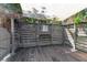 Enclosed outdoor shower area with wooden deck, a partial canopy, and a gray horizontal plank privacy fence at 259 S Polk Dr, Sarasota, FL 34236