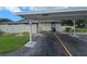 Exterior view features the property's parking area and adjacent carport, with well-maintained landscaping visible in the background at 2606 29Th Ave W # 12, Bradenton, FL 34205