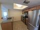 Well-lit kitchen showcasing stainless steel appliances, granite countertops, tile flooring, and an overhead skylight enhancing the space at 2606 29Th Ave W # 12, Bradenton, FL 34205